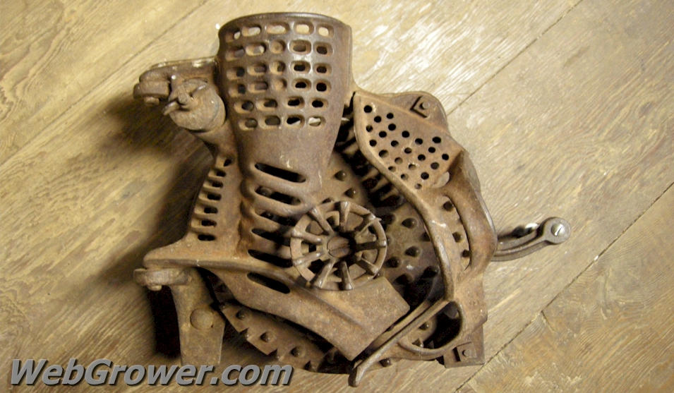 An antique, hand cranked corn sheller.